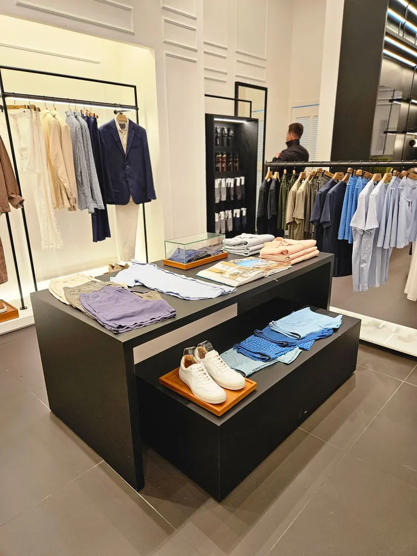 Ilha central, araras e expositores para boutique de moda